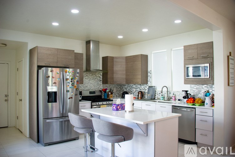 A modern kitchen with a refrigerator, stove, and sink.