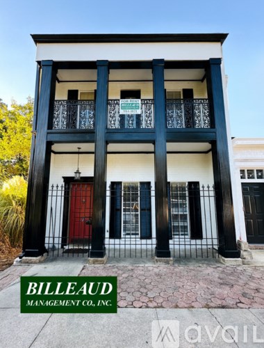 A building with a red door and a sign that says "Billeaud Management Co., Inc."