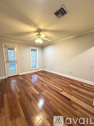 A room with wooden flooring and a ceiling fan.