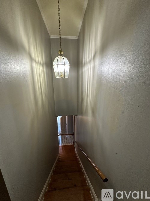 A long hallway with a light hanging from the ceiling.