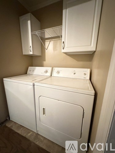 A white washing machine and dryer in a small room.