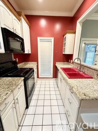 A kitchen with red walls and white cabinets.