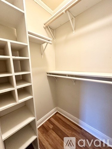 A white shelving unit with multiple compartments is mounted on a wall.