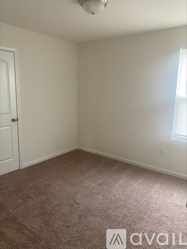 A room with carpeted floor and a door.