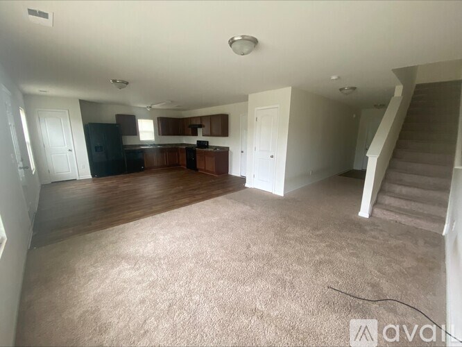 A spacious living room with a staircase leading to the upper floor.