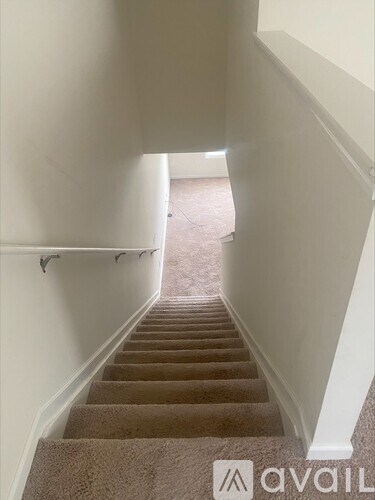 A staircase with a carpeted runner and white walls.
