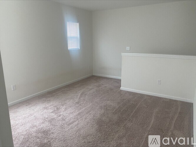 A room with a carpeted floor and a window letting in natural light.