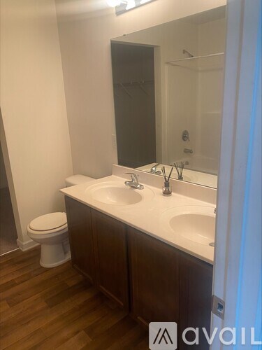 A bathroom with a toilet, sink, and mirror.