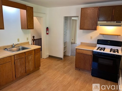 A kitchen with wooden cabinets and a black stove top oven.