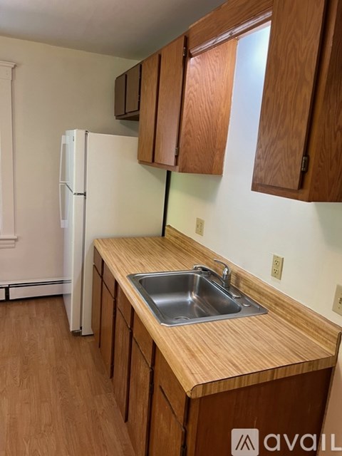 A kitchen with wooden cabinets and a white fridge.