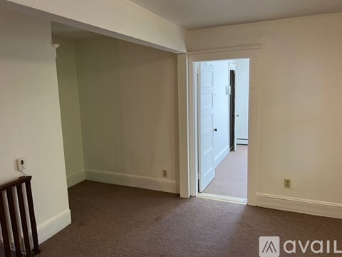 A room with a carpeted floor and a doorway leading to another room.