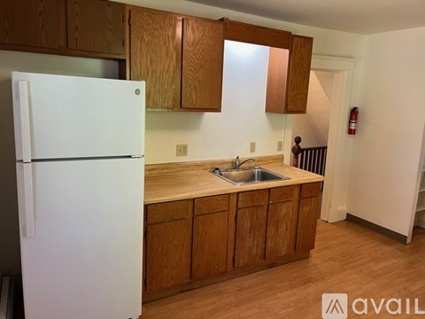 A kitchen with wooden cabinets and a white fridge.