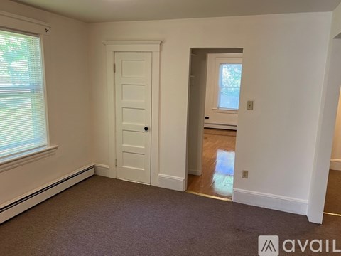 A room with a white door and a window with blinds.