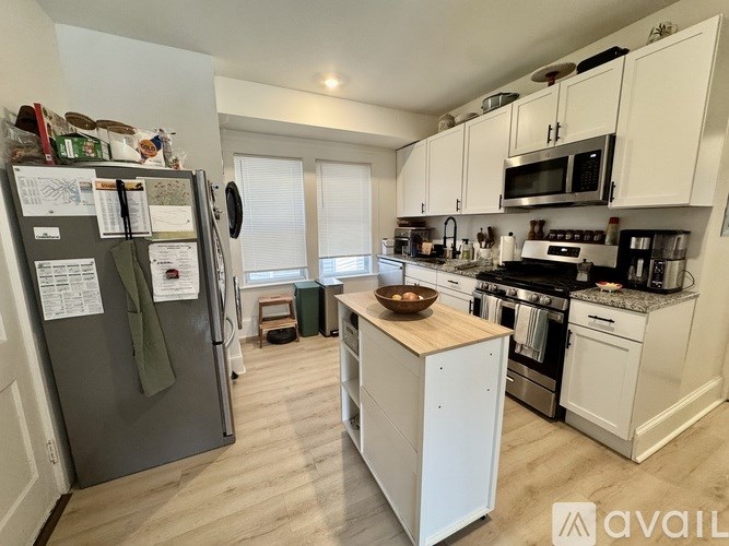 A kitchen with a refrigerator, oven, and microwave.