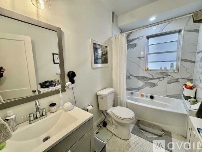 A bathroom with a marble patterned wall and a white toilet.