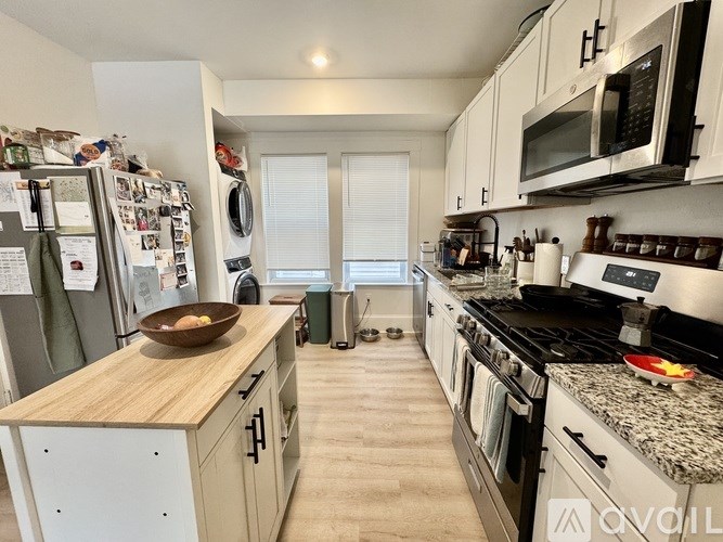 A kitchen with a refrigerator, oven, and microwave.