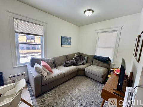 A living room with a grey couch and a television.