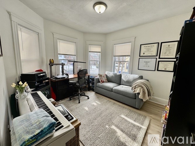 A living room with a piano, a couch, and a chair.
