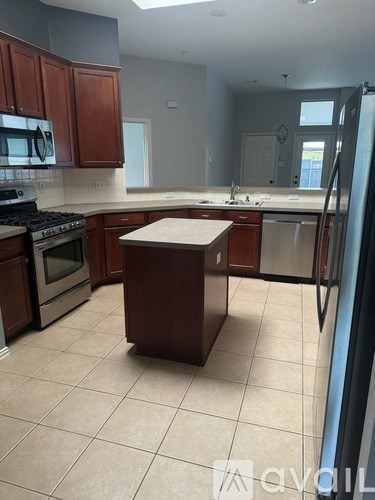 A kitchen with brown cabinets and a white island.