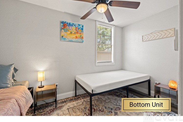 A bedroom with a bed, a nightstand with a lamp, and a mattress on a frame.