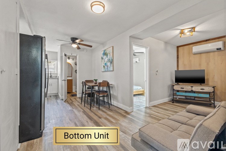 A living room with a couch, a dining table, and a television.