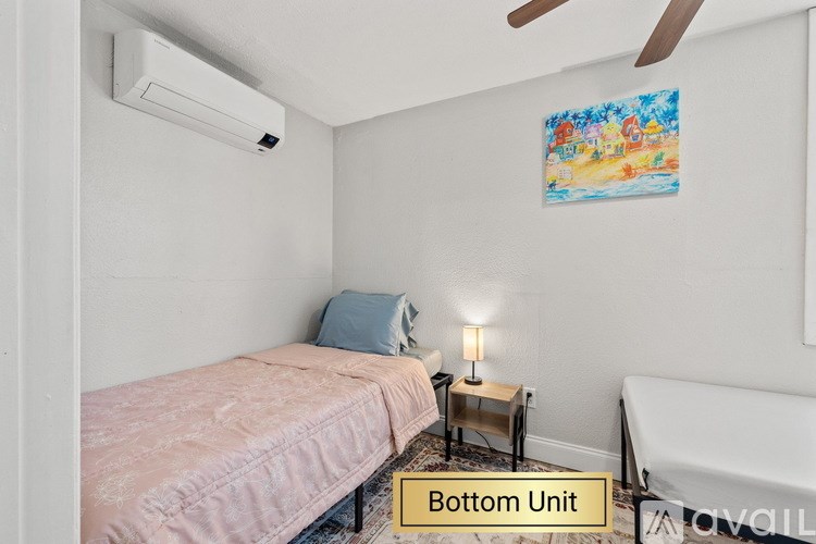 A bedroom with a bed, nightstand, and a painting on the wall.