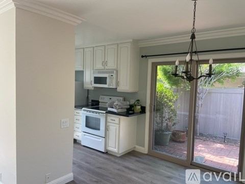 A kitchen with white cabinets and a microwave above the stove.
