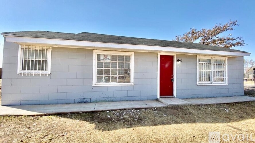 A small house with a red door and white walls.