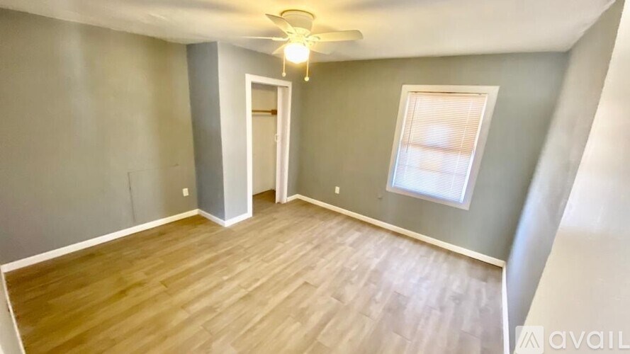 A room with wooden flooring and a ceiling fan.