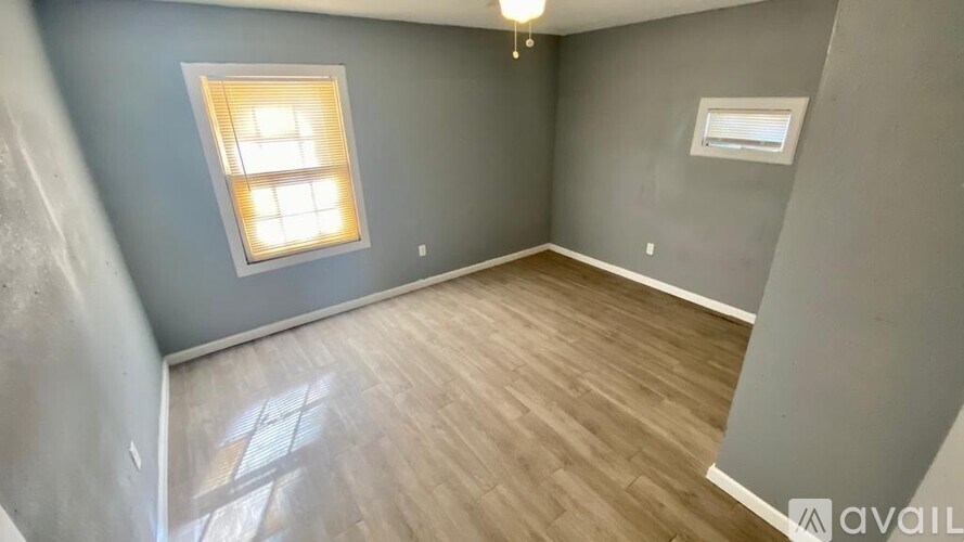 A room with wooden flooring and a window.