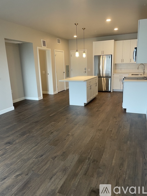 A kitchen with a refrigerator, sink, and cabinets.