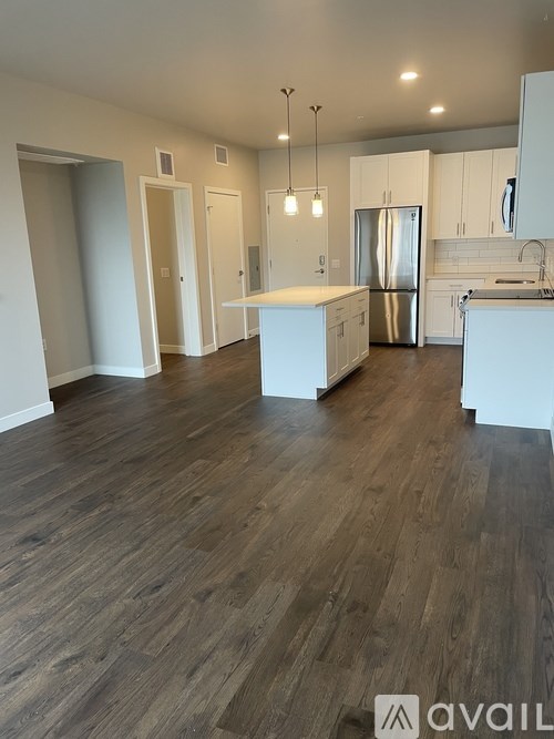 A kitchen with a refrigerator, sink, and cabinets.