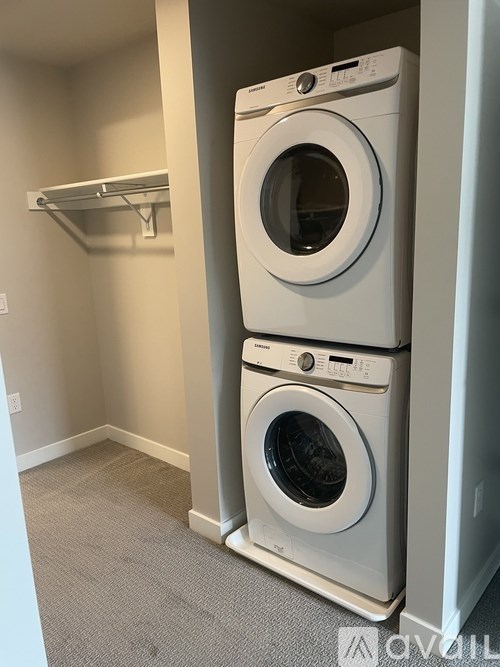 Two white front loading washing machines in a laundry room.