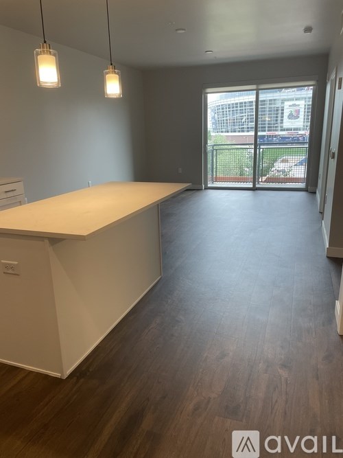 A large open space with a white counter and wooden flooring.