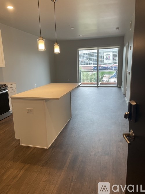 A kitchen with a white countertop and wooden flooring.