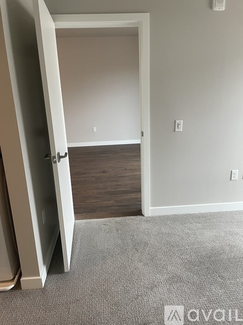 A room with a carpeted floor and a white door.