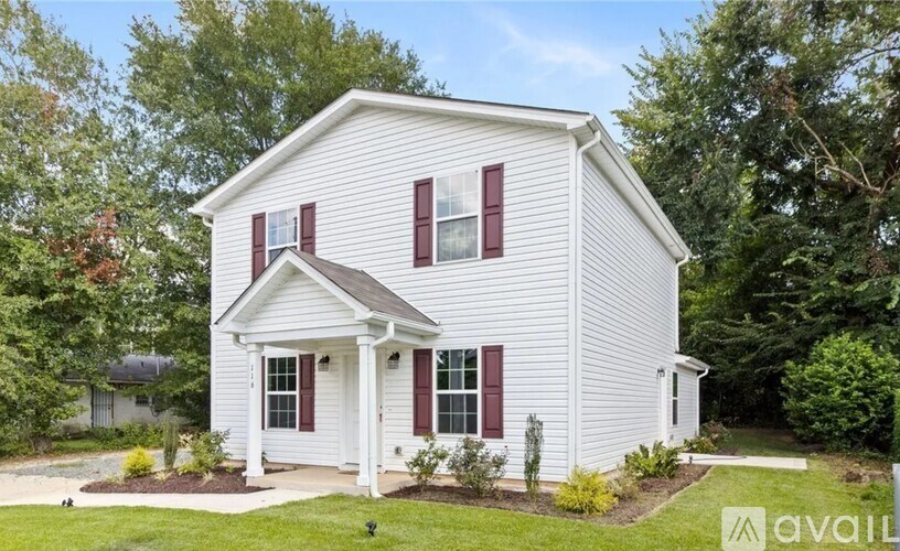 A white house with red shutters and a small front porch.