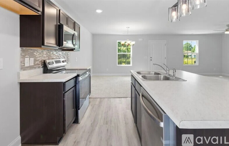 A modern kitchen with dark brown cabinets and stainless steel appliances.