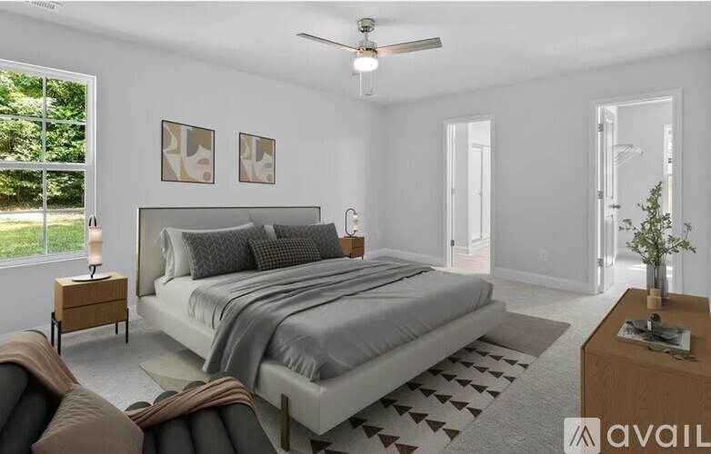 A bedroom with a large bed and a ceiling fan.