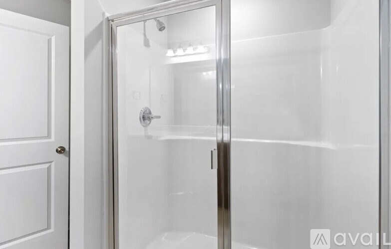A white door with a glass shower stall in the background.