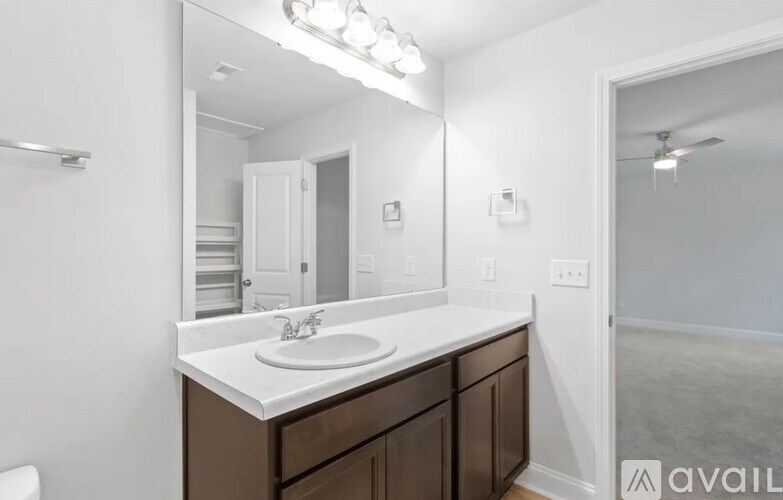 A bathroom with a sink, mirror, and a toilet.