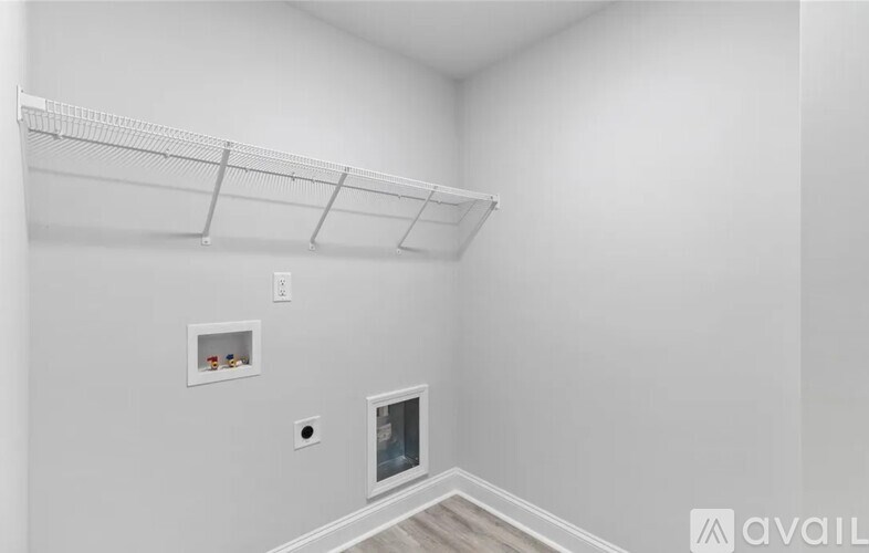 A white wall with a shelf and a small window.