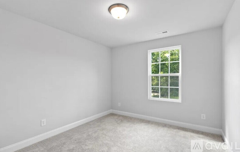A room with a window and carpeted floor.