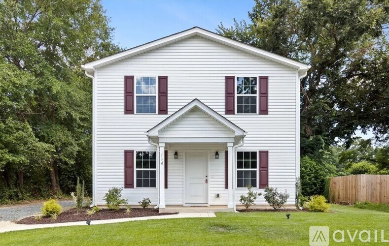 A white house with a red door and windows.