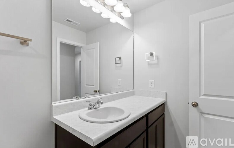 A bathroom with a white sink and a mirror.