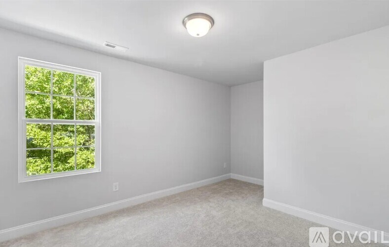 A room with a window and a carpeted floor.