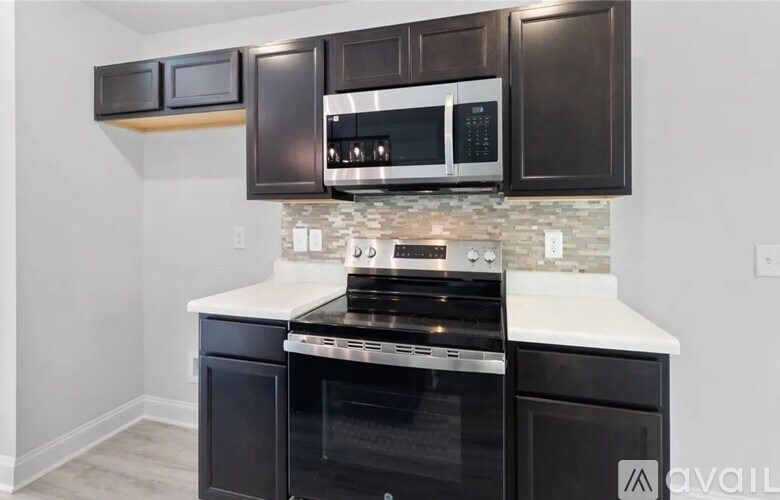A kitchen with black cabinets and a white countertop.