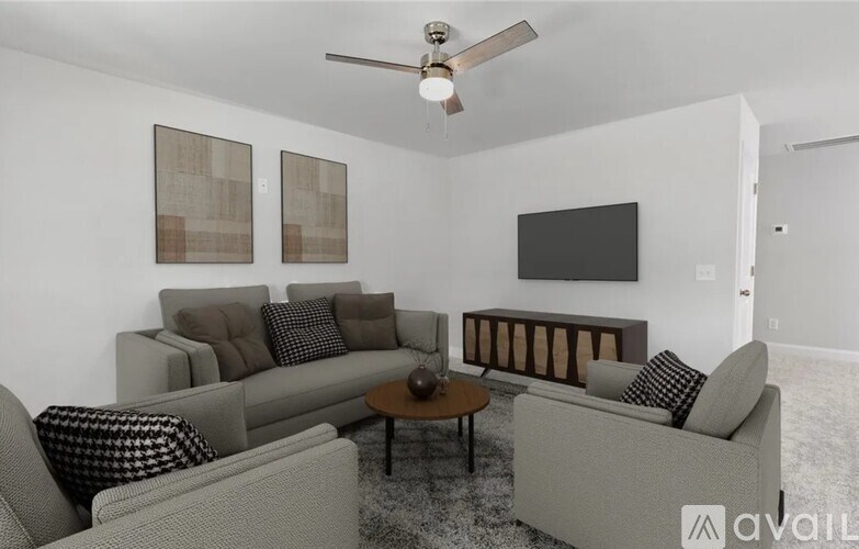 A living room with a grey couch, a coffee table, and a ceiling fan.