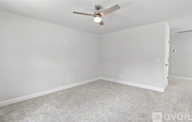 A room with a ceiling fan and carpeted floor.