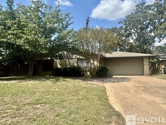 A house with a driveway and a tree in front.